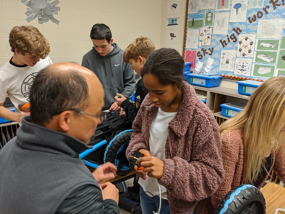 Middle school students working on Go Baby Go vehicle parts