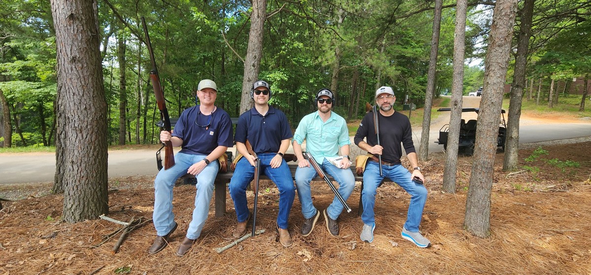 Group of 4 at the clays event on a bench