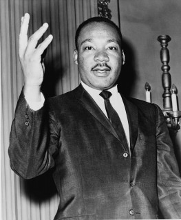 Dr. Martin Luther King, Jr. with one hand raised.
