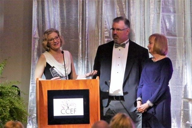 Dr. Falany receiving the alumna of the year award on stage.