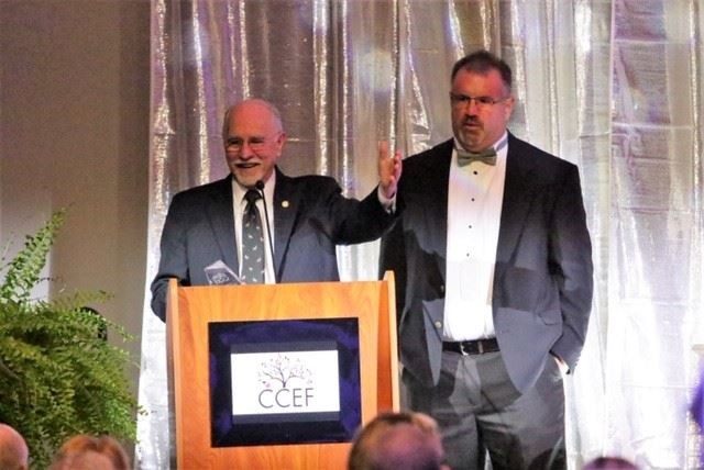 Mr. Hobgood receiving alumnus of the year award on stage.