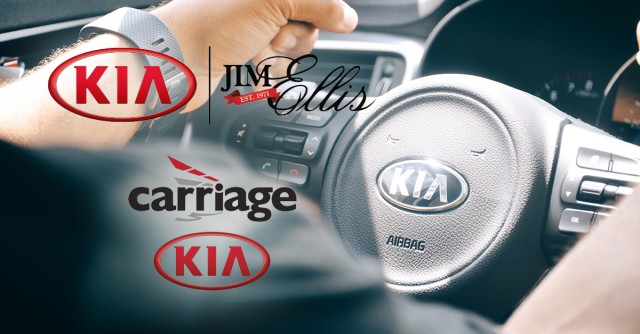 Man holding a black  Kia steering wheel.